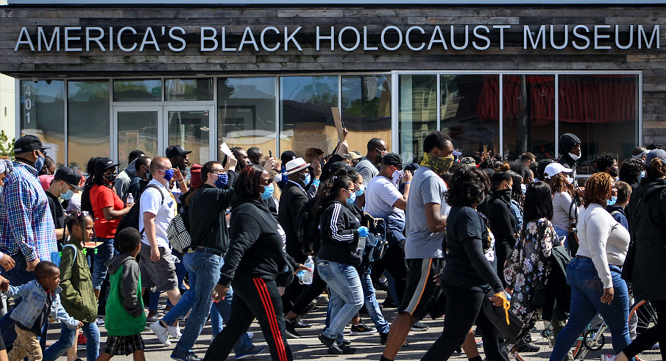 group of people marching in front of America's Black Holocaust Museum